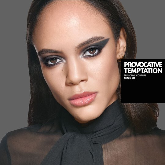 YSL model Kalixte with a bold, graphic black eyeliner look and glossy nude lips, wearing a chic black sheer blouse.