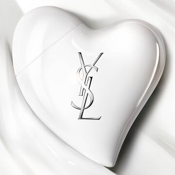 Glossy white heart CARE CRUSH Hand & Body serum-in-cream product with silver YSL logo. Chic skincare packshot.
