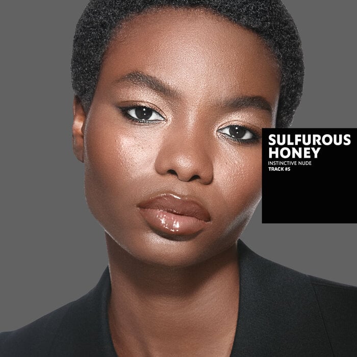 Karen, tanned skin tone, with an instinctive nude eye look and blazing desire glossy lips, wearing a white top.