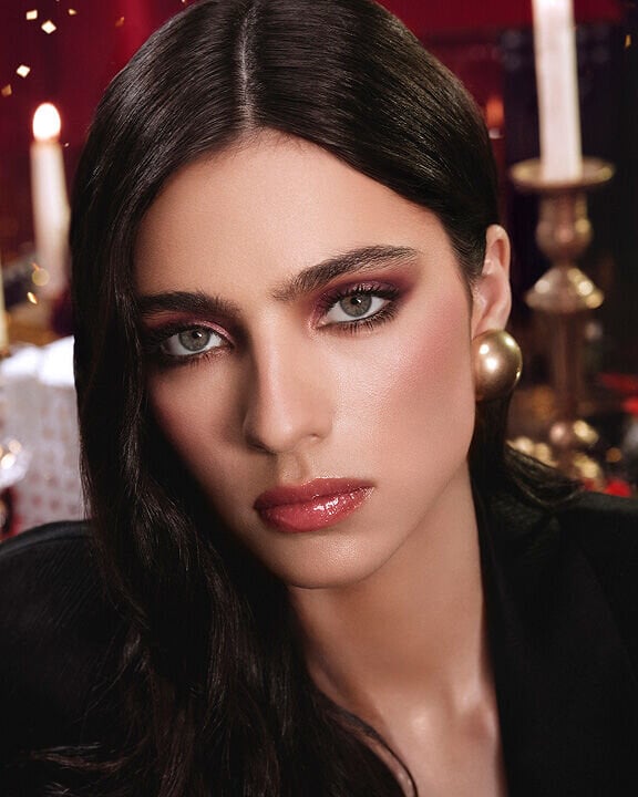 Glamorous model showcasing warm burgundy eyeshadow and defined eyes for the Holiday season.