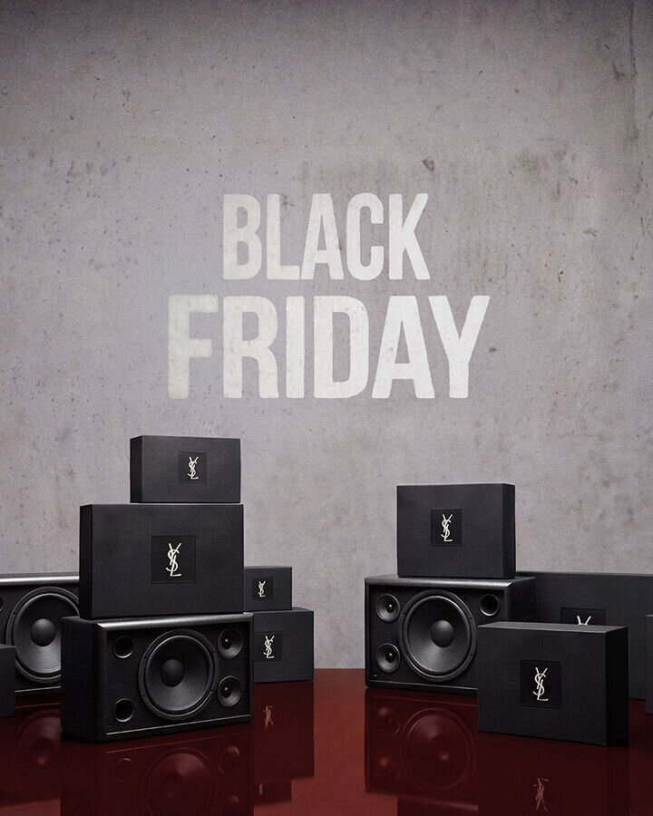 YSL-branded black boxes and speakers on a reflective red floor beneath “BLACK FRIDAY” lettering.