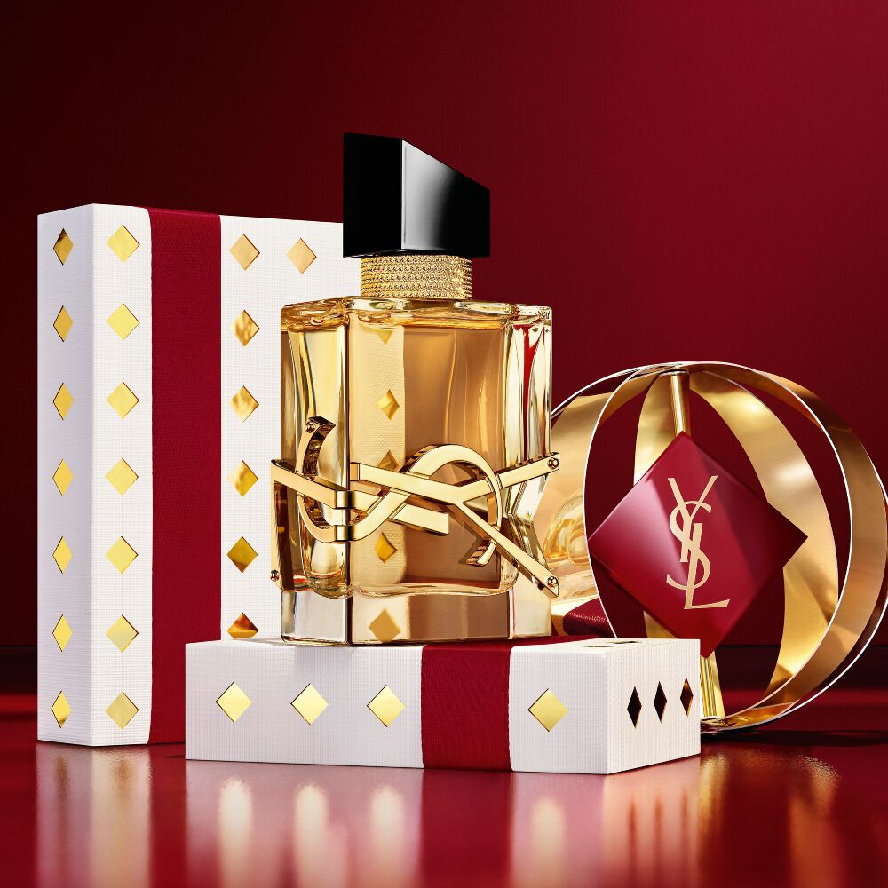 Iconic LIBRE fragrance bottle featured with luxury burgundy and gold YSL gift boxes.