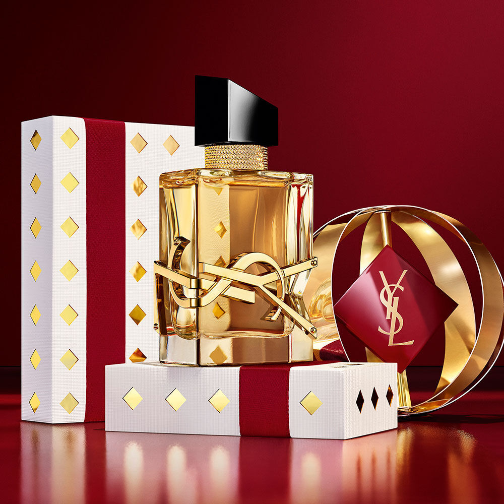 Iconic LIBRE fragrance bottle featured with luxury burgundy and gold YSL gift boxes.
