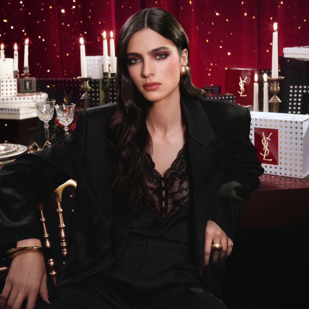  ALT & SEO HOLIDAY  100% B7  Model wearing a black suit and glam look, seated in a festive candlelit setting with YSL gift boxes.      	 Model wearing a black suit and glam look, seated in a festive candlelit setting with YSL gift boxes.  Model wearing a black suit and glam look, seated in a festive candlelit setting with YSL gift boxes. B7 Banner hidden