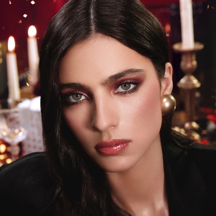 Glamorous model showcasing warm burgundy eyeshadow and defined eyes for the Holiday season.