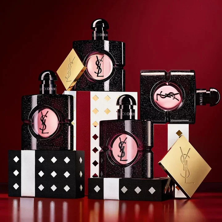 Multiple YSL LIBRE fragrance bottles layered over luxury gold-patterned Holiday gift packaging.