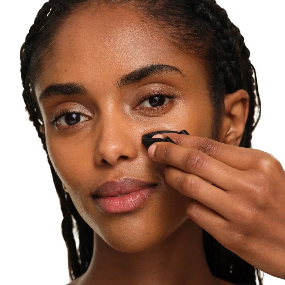 Close-up showing how to fold the YSL makeup puff for targeted precision and touch-ups around the nose and eyes.