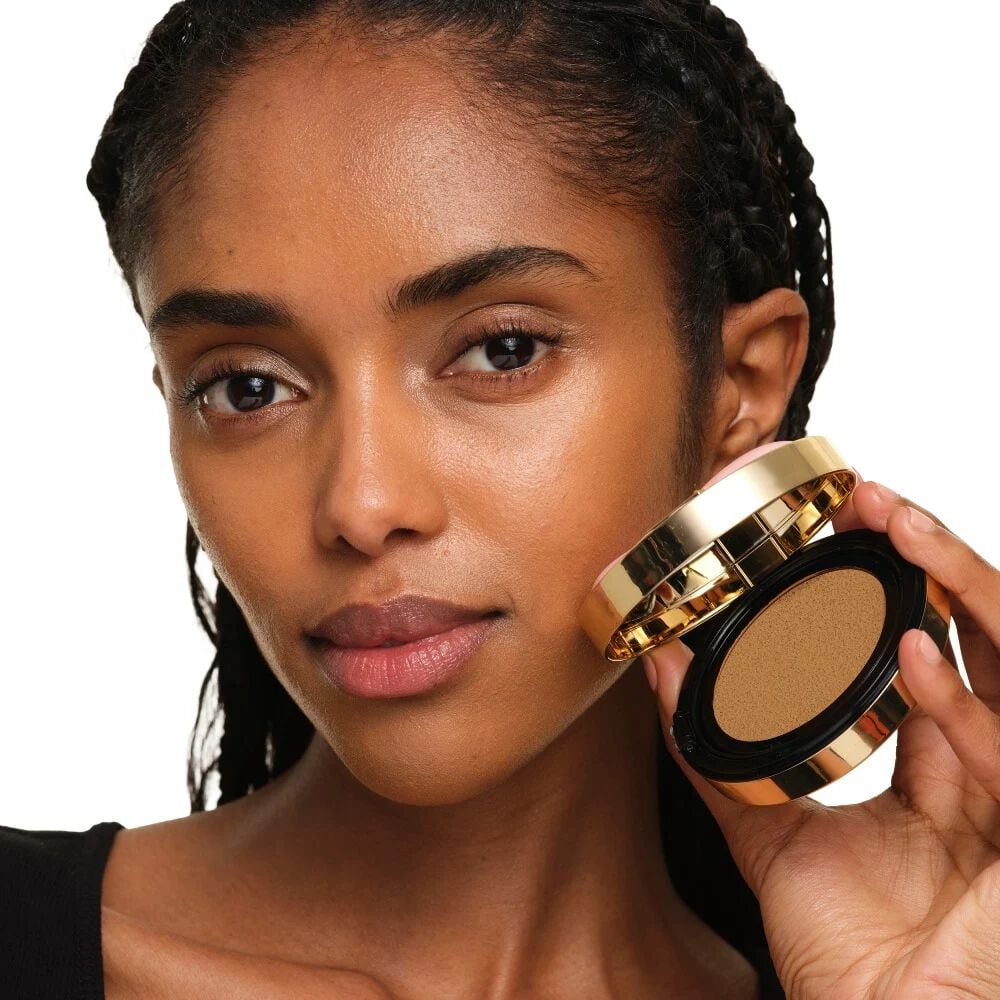 Model with medium skin holding YSL SKIN AFFAIR SOFT GLOW CUSHION. Radiant, unified and natural-looking complexion.