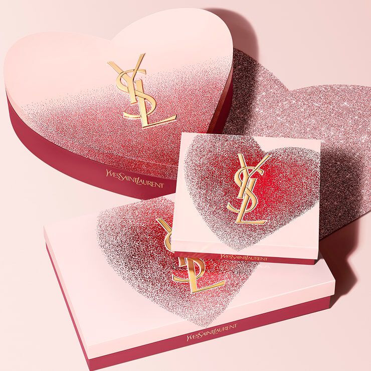 YSL Beauty Valentine's day gift sets in heart-shaped
boxes with gold YSL logo, featuring a glittery red and
pink design.
