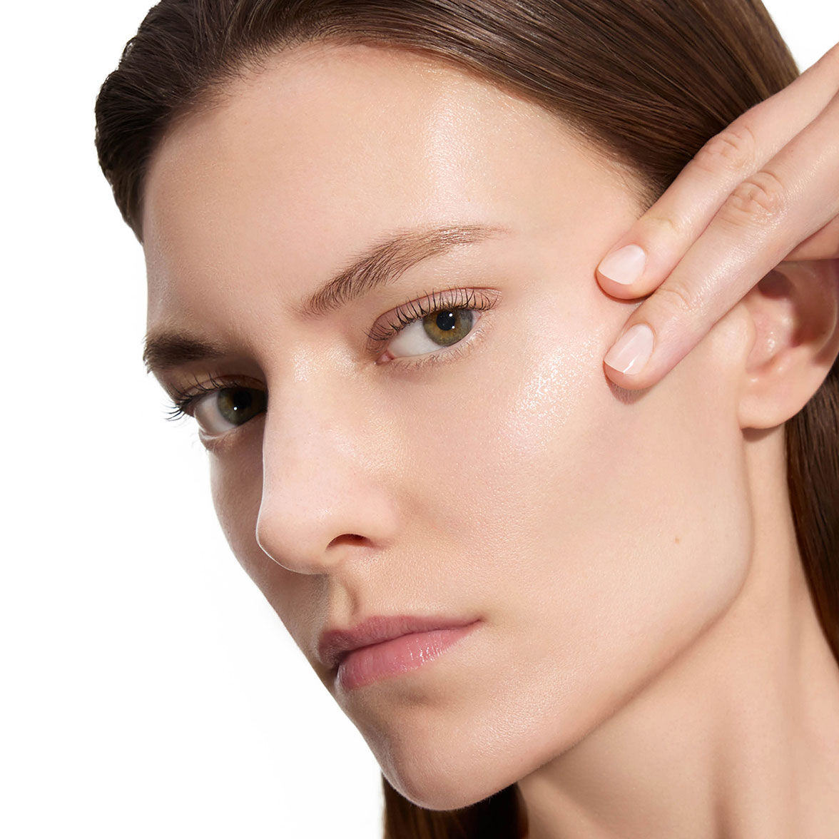 Marije, YSL Beauty model, with fair skin, gently touching her cheek, showcasing smooth skin after lotion application.