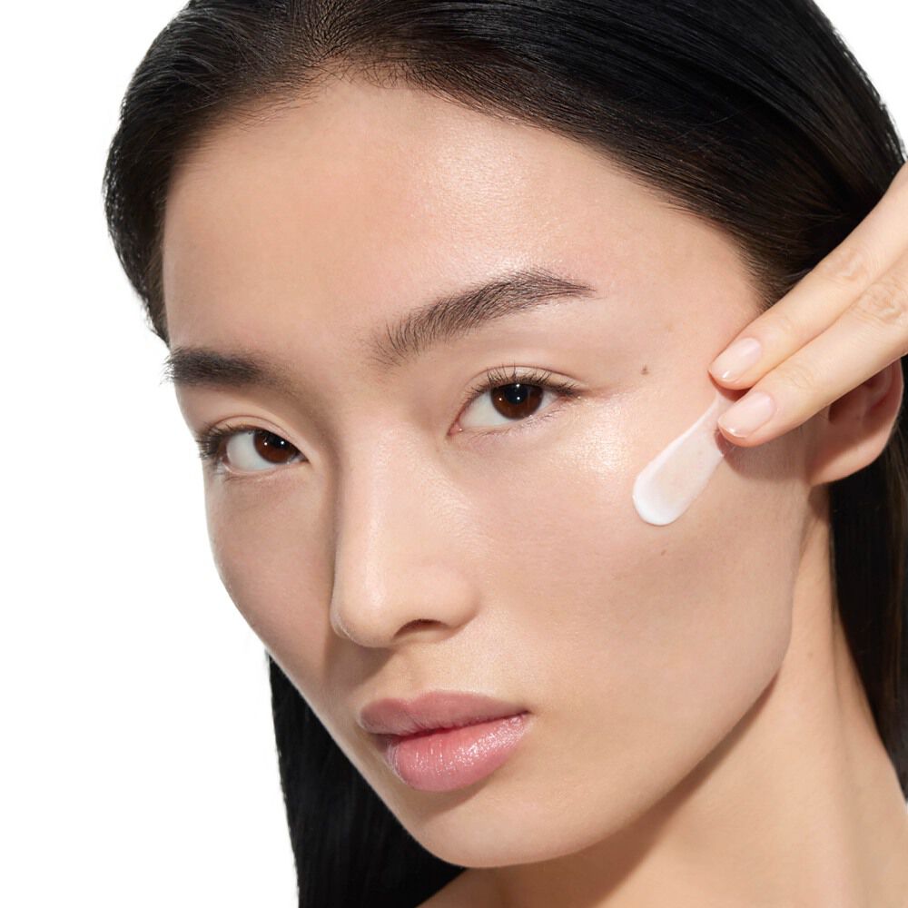 Wen, YSL Beauty model, with light skin, applying YSL Beauty Pure Shots Youth Reload Cream to her cheek.