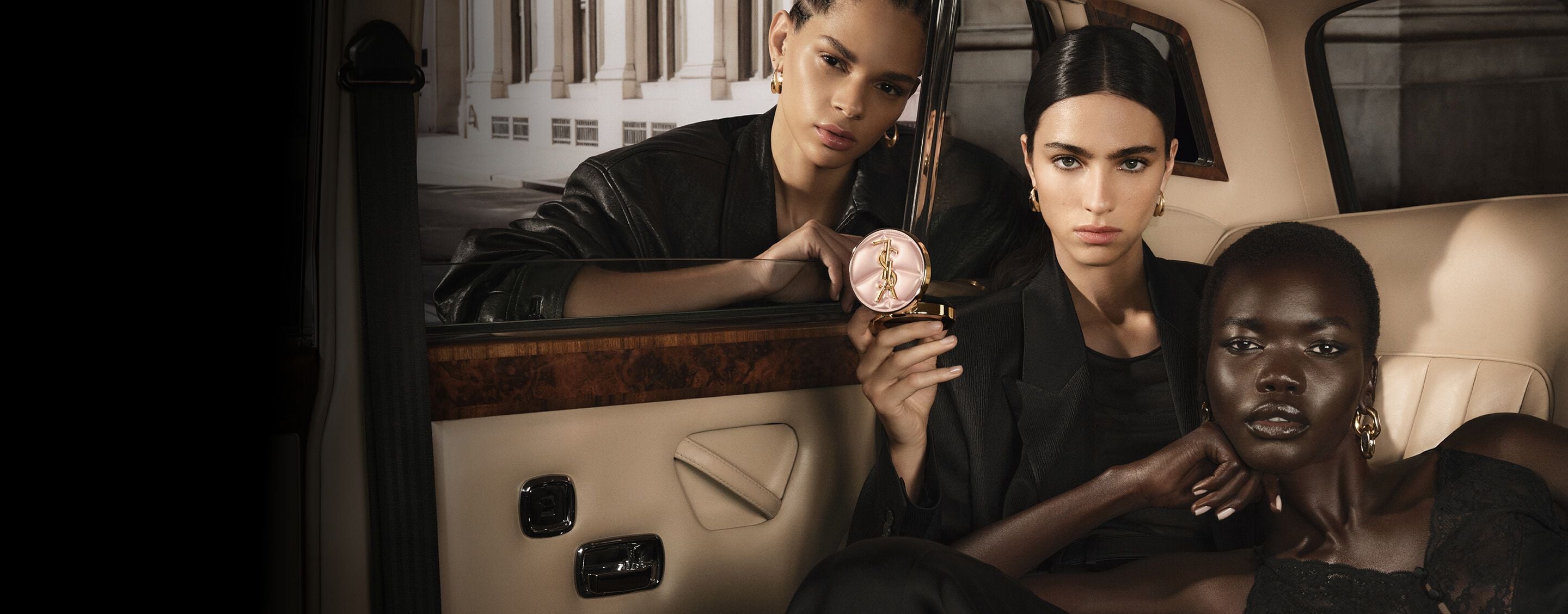 Three models in a taxi with YSL SKIN AFFAIR CUSHION. Diverse skin tones and high-fashion radiant complexions.